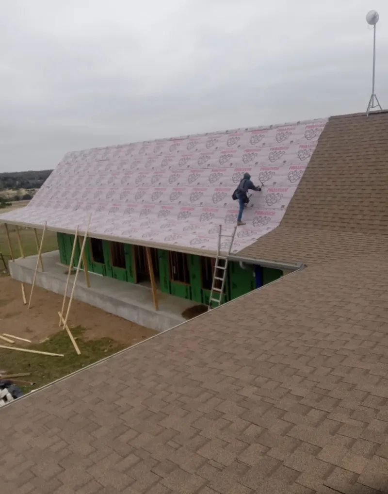 Worker preparing underlayment for a metal roof installation in Munhall